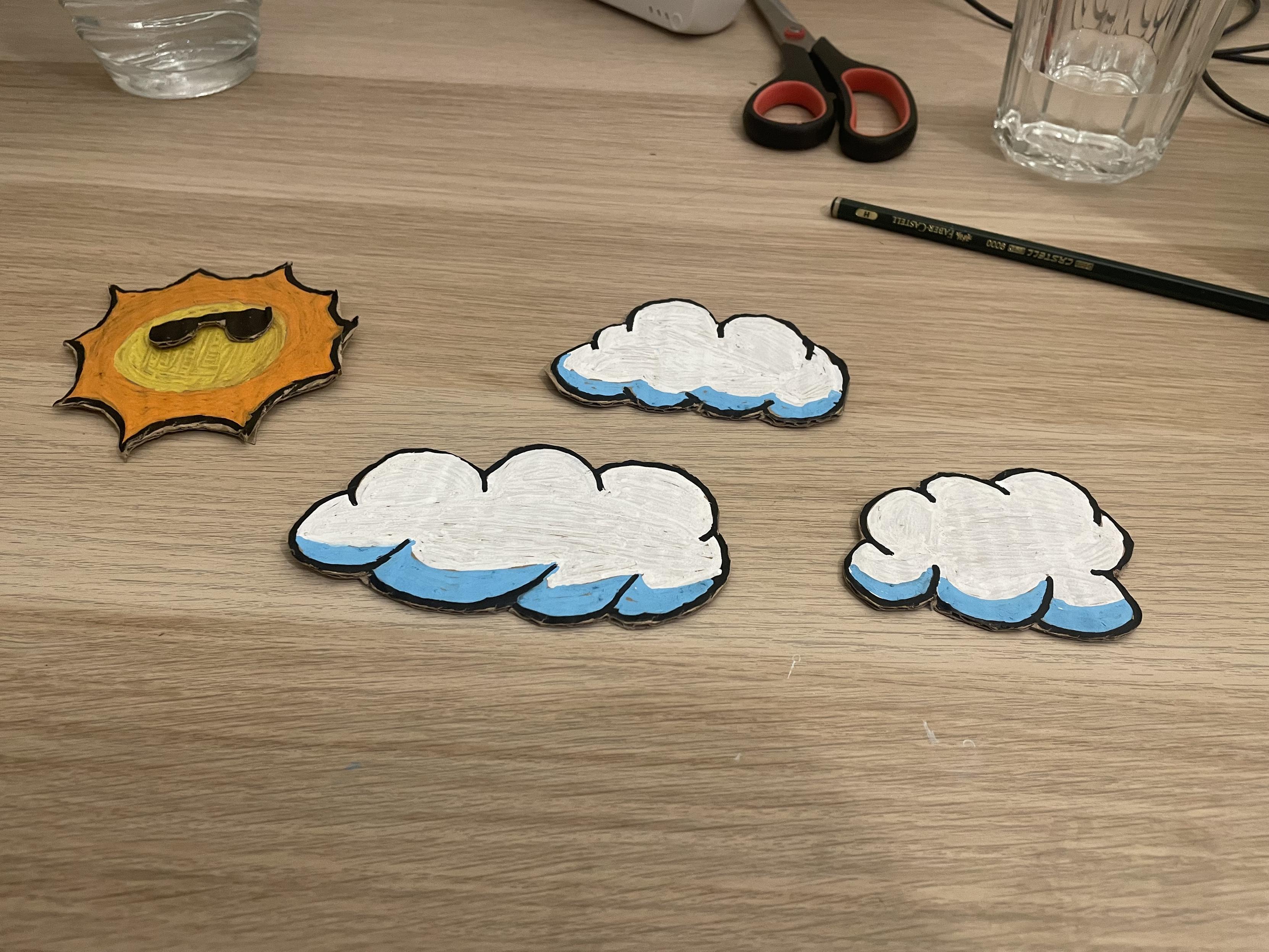 the sun and clouds from the demo as actual cardboard objects on a table